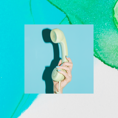 Hand holding phone handset with abstract background